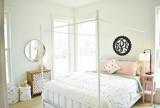 bedroom with multiple windows and hardwood / wood-style floors