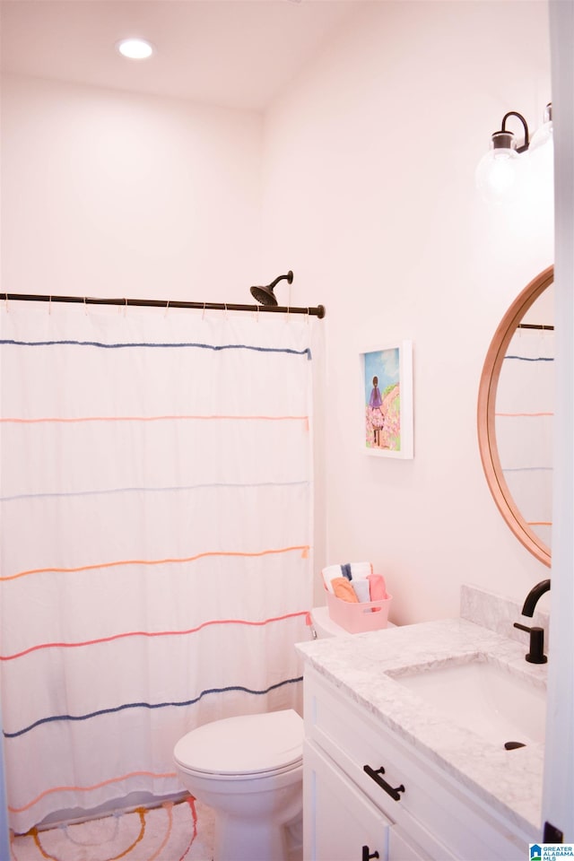 bathroom with curtained shower, vanity, and toilet