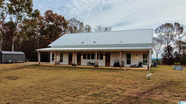 back of house with central AC unit, a lawn, and covered porch