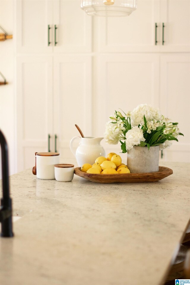 room details with light stone countertops and white cabinets