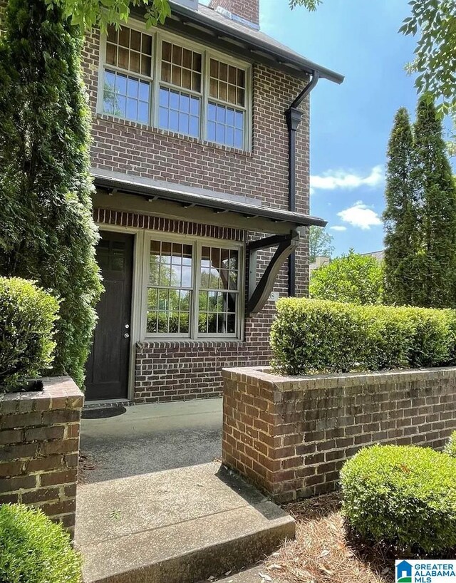 exterior space with a chimney and brick siding