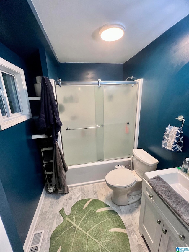 full bathroom featuring wood-type flooring, shower / bath combination with glass door, vanity, and toilet