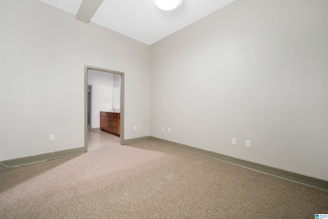 empty room featuring light carpet and lofted ceiling