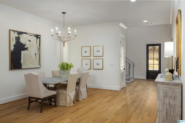 dining space featuring visible vents, light wood-style floors, baseboards, a chandelier, and stairs