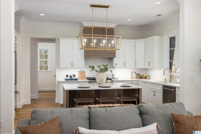 kitchen featuring light countertops, tasteful backsplash, open floor plan, and a sink