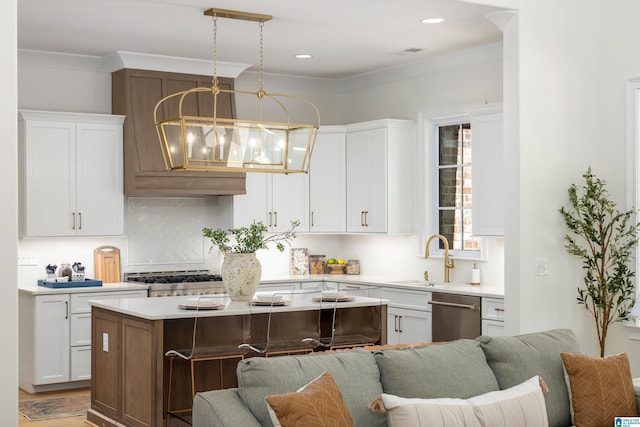 kitchen featuring stainless steel dishwasher, light countertops, open floor plan, and a sink