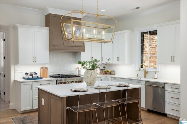 kitchen featuring visible vents, a sink, stainless steel dishwasher, light countertops, and range