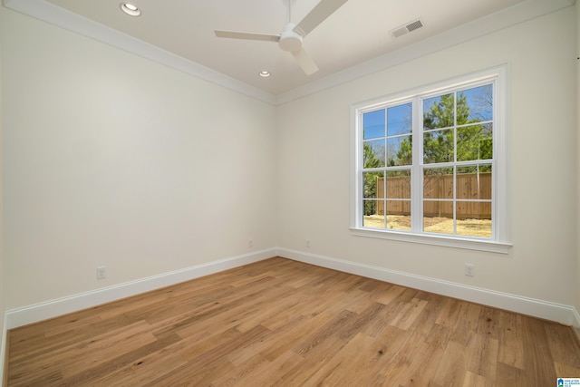 unfurnished room with a ceiling fan, baseboards, visible vents, light wood finished floors, and ornamental molding