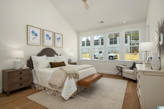 bedroom with visible vents, multiple windows, light wood-style floors, and lofted ceiling