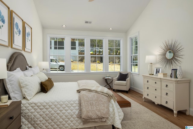 bedroom featuring visible vents, wood finished floors, recessed lighting, baseboards, and lofted ceiling