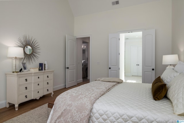 bedroom featuring visible vents, baseboards, and wood finished floors