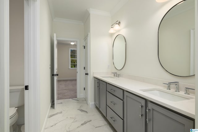 full bath featuring double vanity, marble finish floor, ornamental molding, and a sink