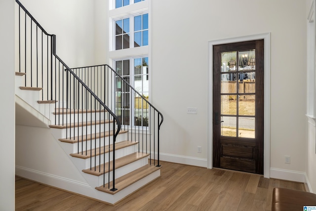 entryway featuring stairs, wood finished floors, and baseboards