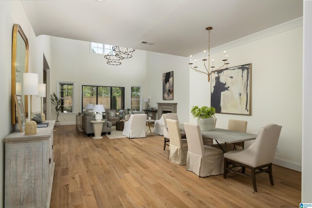 dining room with a notable chandelier, visible vents, baseboards, and light wood-style floors