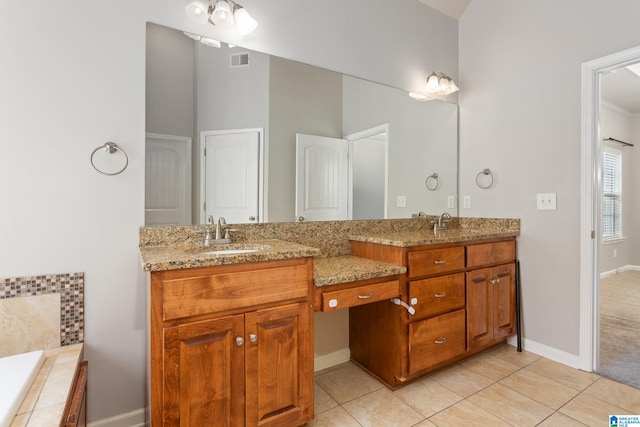 bathroom with vanity, tiled bath, and tile patterned flooring