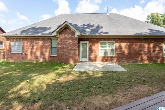 rear view of house with a patio and a lawn