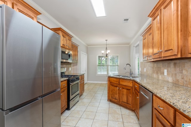 kitchen with light stone counters, sink, backsplash, a chandelier, and stainless steel appliances