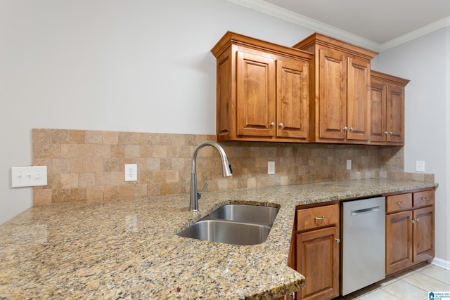 kitchen with light stone counters, light tile patterned flooring, sink, backsplash, and ornamental molding