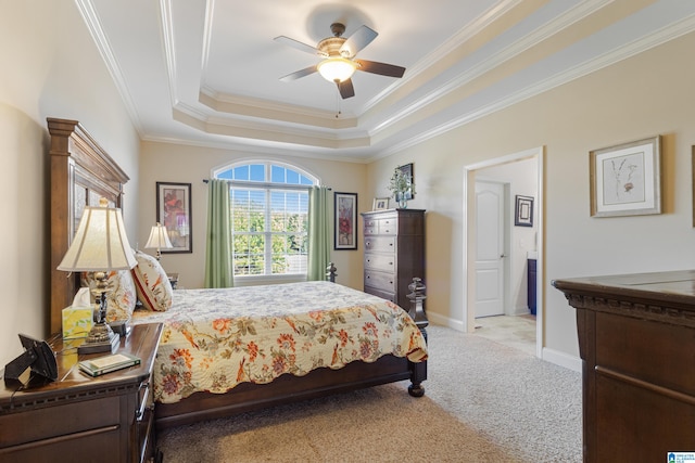 bedroom with ornamental molding, a raised ceiling, ceiling fan, and light colored carpet