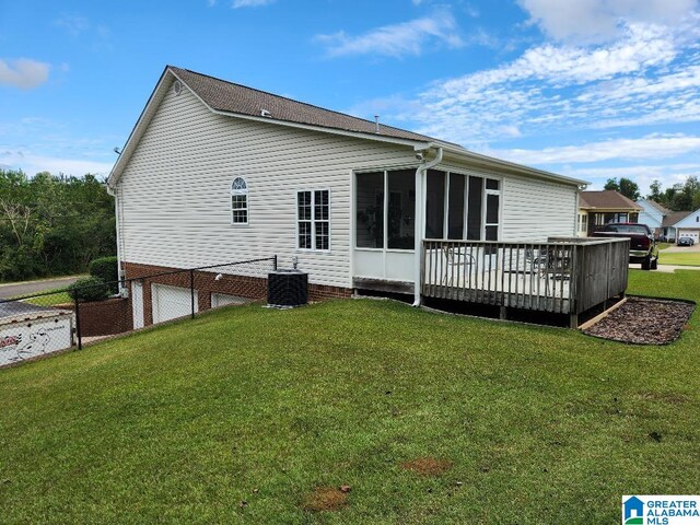 back of property with a deck, a lawn, and central air condition unit