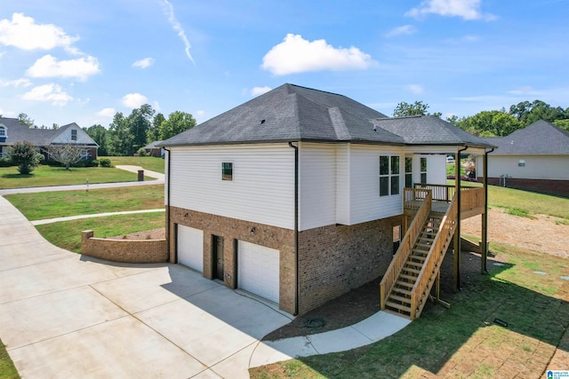 view of side of property with a garage, a deck, and a yard