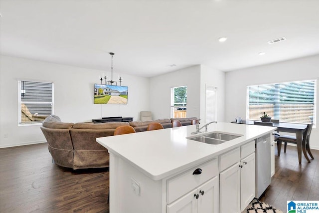 kitchen featuring dark wood-type flooring, sink, an island with sink, white cabinetry, and stainless steel dishwasher