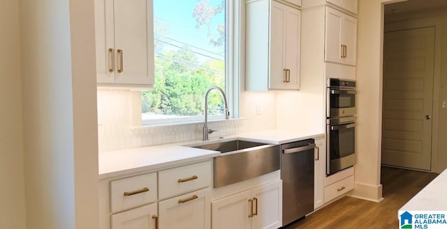 kitchen featuring white cabinets, stainless steel appliances, sink, and dark hardwood / wood-style flooring