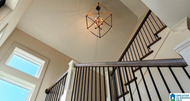 stairs with a notable chandelier and a towering ceiling