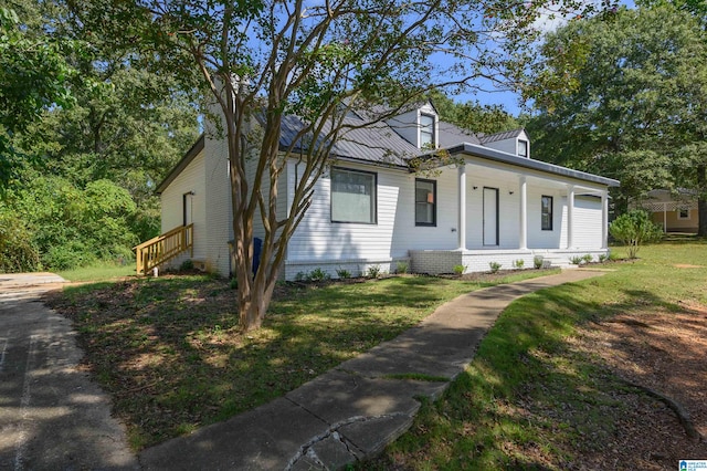 new england style home with a porch and a front lawn