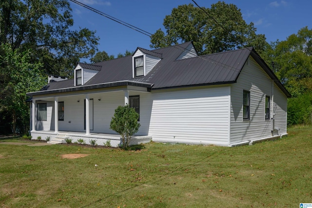 cape cod house with a front yard and covered porch