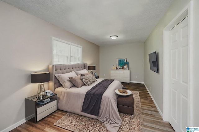 bedroom featuring a textured ceiling and hardwood / wood-style flooring