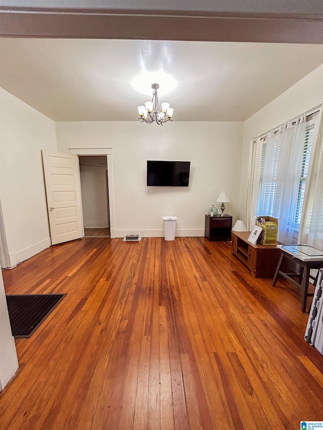 miscellaneous room with a notable chandelier and wood-type flooring