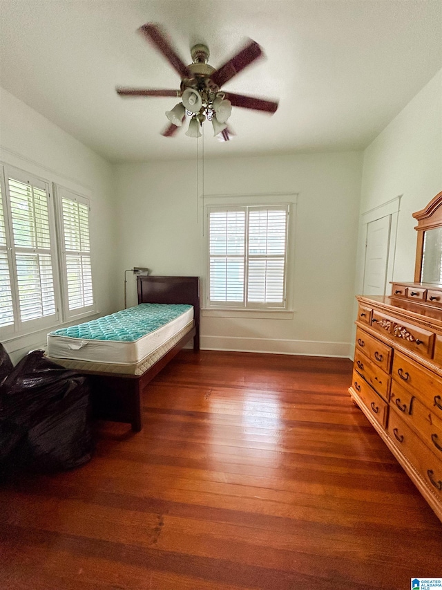 bedroom with dark hardwood / wood-style flooring and ceiling fan