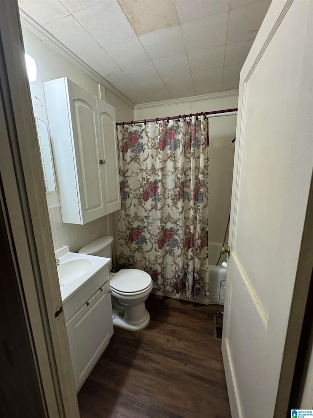 full bathroom with vanity, shower / tub combo, hardwood / wood-style flooring, crown molding, and toilet