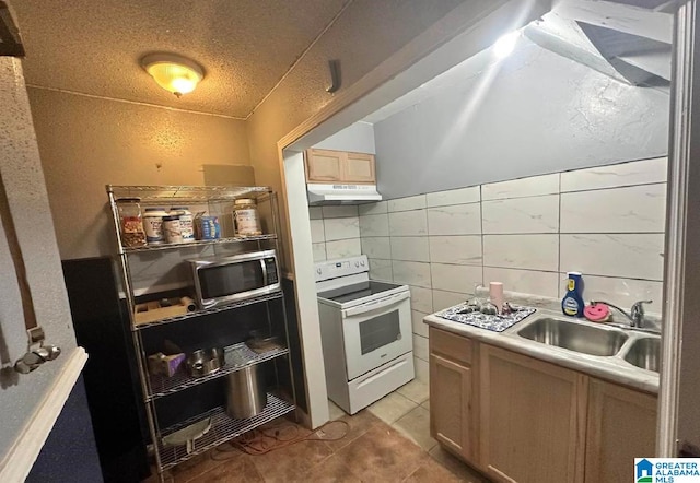 kitchen featuring light brown cabinets, light tile patterned flooring, sink, a textured ceiling, and electric range