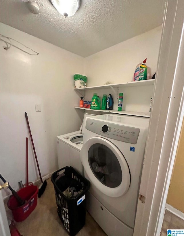 washroom featuring washer and clothes dryer and a textured ceiling