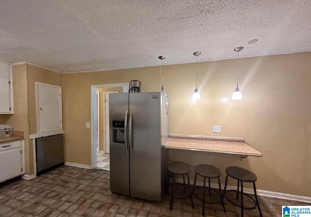 kitchen featuring pendant lighting, stainless steel refrigerator with ice dispenser, a textured ceiling, and white cabinetry