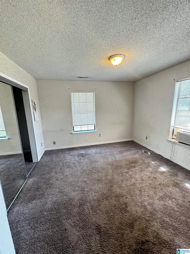 carpeted empty room with a textured ceiling