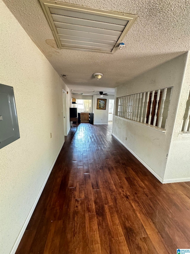 hallway featuring a textured ceiling, electric panel, and dark hardwood / wood-style flooring