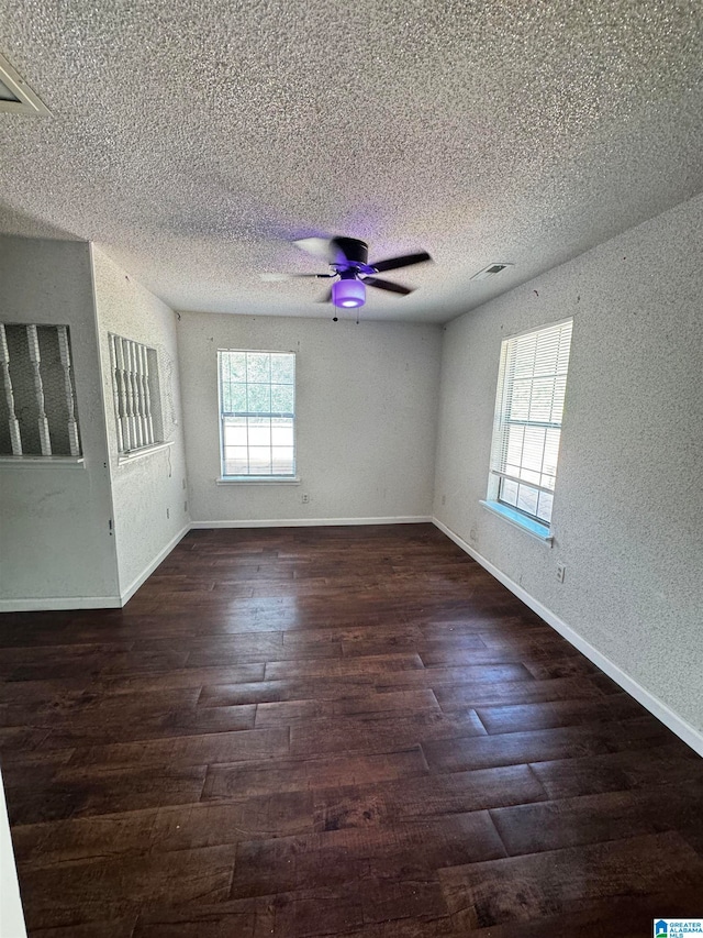 unfurnished room with a textured ceiling and dark hardwood / wood-style floors