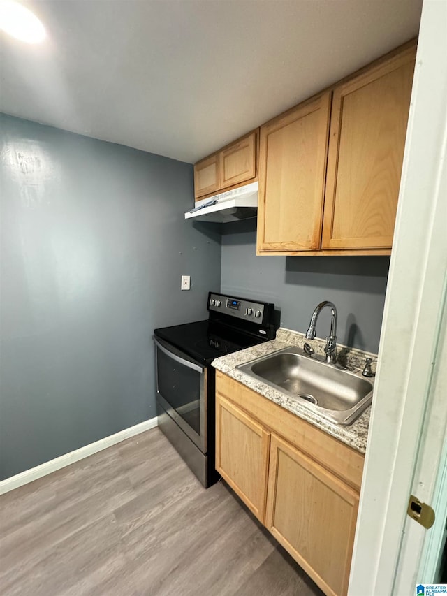 kitchen with light hardwood / wood-style flooring, light brown cabinetry, stainless steel electric stove, and sink