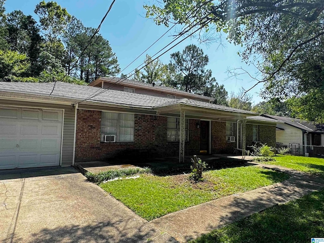 ranch-style home with cooling unit, a front yard, and a garage