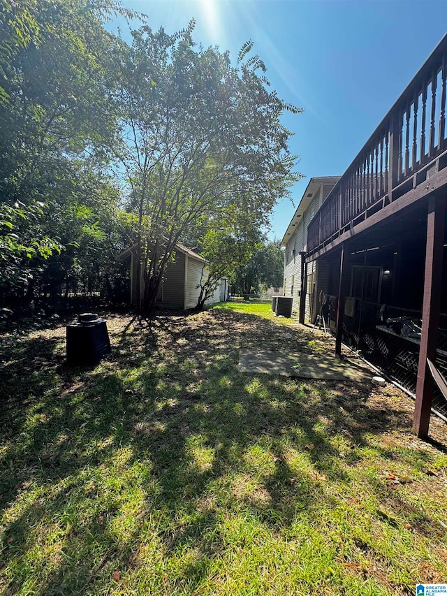 view of yard with a deck and central air condition unit