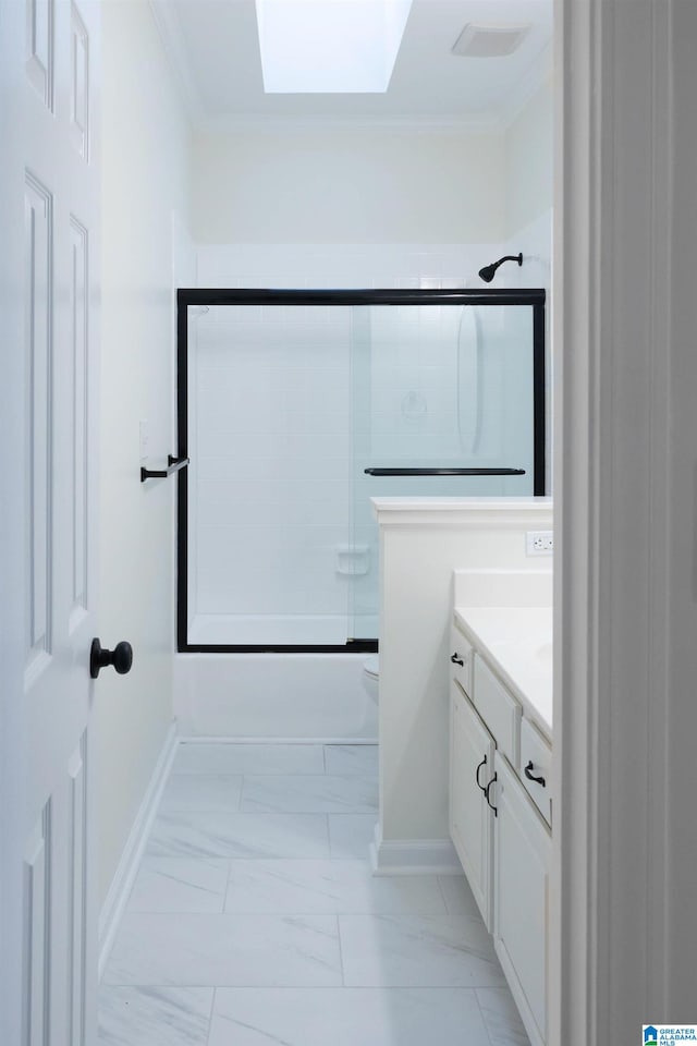 full bathroom with a skylight, toilet, shower / bath combination with glass door, vanity, and ornamental molding