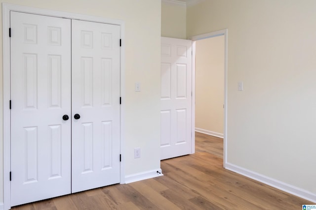 unfurnished bedroom featuring light hardwood / wood-style floors and a closet