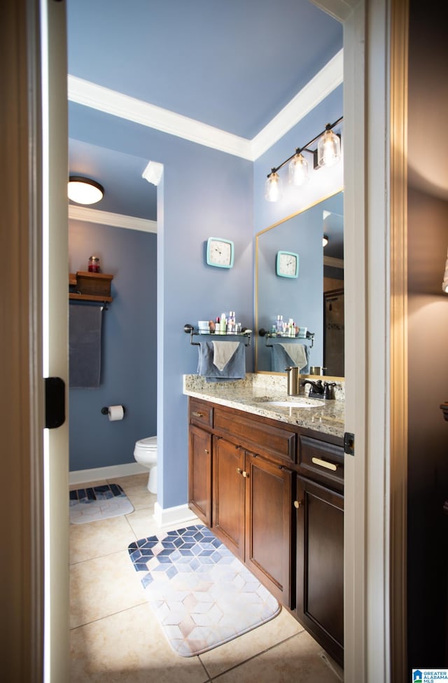 bathroom with tile patterned floors, crown molding, vanity, and toilet