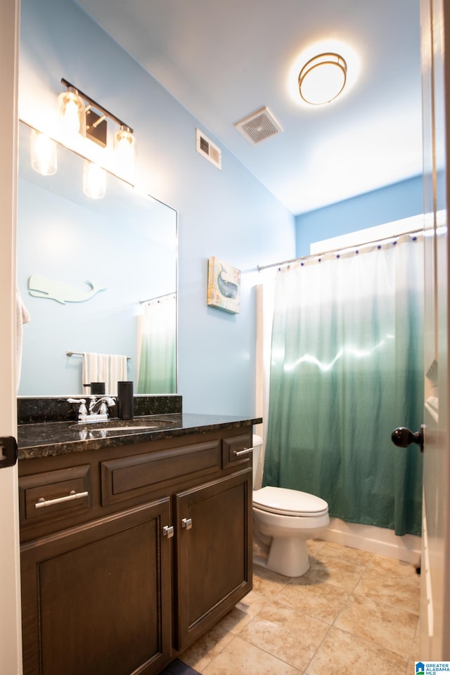 bathroom featuring tile patterned flooring, vanity, and toilet