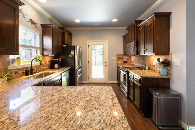 kitchen featuring light stone counters, dark hardwood / wood-style floors, sink, backsplash, and appliances with stainless steel finishes