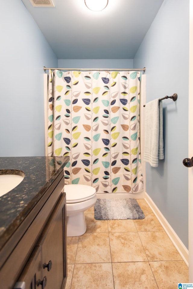 bathroom featuring tile patterned floors, walk in shower, vanity, and toilet