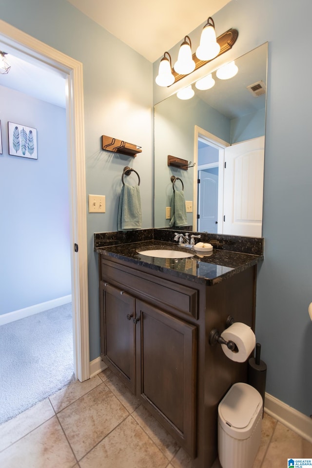 bathroom with tile patterned flooring, vanity, and toilet